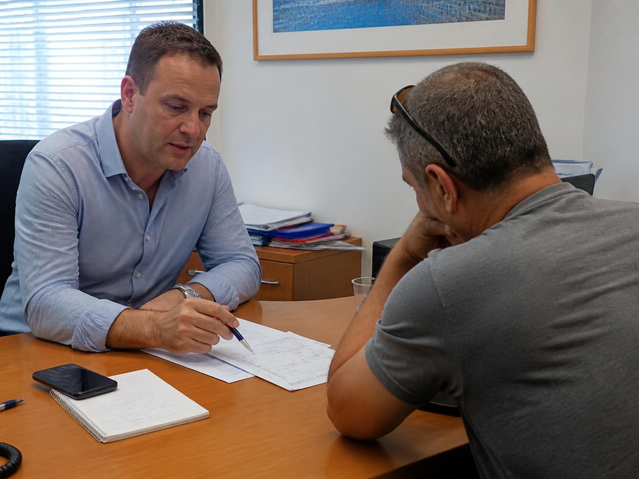 יועץ פיננסי בפגישה אישית עם לקוח סביב שולחן עבודה